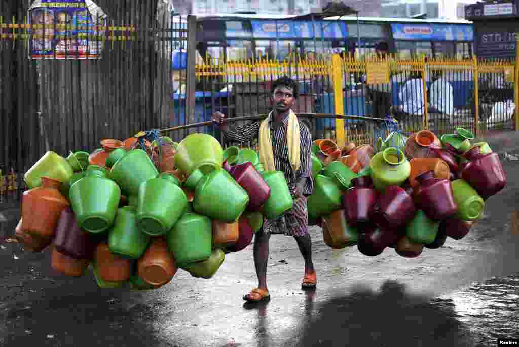 A man carries empty water pitchers for sale in a market in the southern Indian city of Bangalore. 