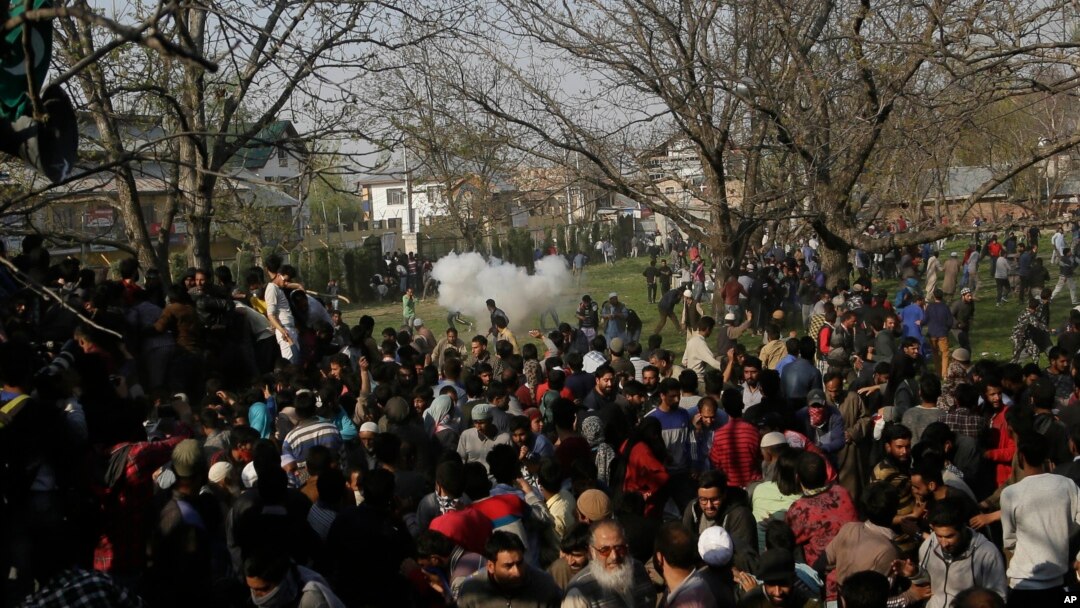 Warga desa Kashmir berusaha mencari perlindungan setelah ledakan gas air mata terjadi di dekat upacara pemakaman seorang anggota separatis di Shopian, selatan Srinagar, Kashmir-India, Minggu (1/4). 