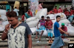 FILE - Bangladeshi laborers wait for work at a market area in Dhaka, Bangladesh, Aug. 13, 2016. But some in the low-lying delta nation are worried that the staggering influx of Rohingyas, if allowed to stay, could push the country’s resources and economy to the brink.