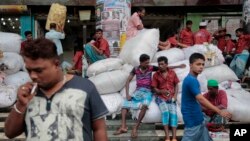 FILE - Bangladeshi laborers wait for work at a market area in Dhaka, Bangladesh, Aug. 13, 2016. But some in the low-lying delta nation are worried that the staggering influx of Rohingyas, if allowed to stay, could push the country’s resources and economy