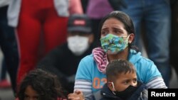 Una mujer sostiene a su hijo en la fronteta entre Colombia y Venezuela durante una protesta ante el bloqueo al paso de buses, el 29 de abril de 2020.