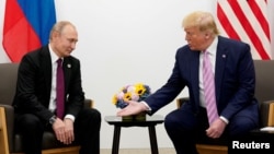 Donald Trump memberi isyarat saat pertemuan dengan Presiden Rusia Vladimir Putin di KTT G20, Osaka, Jepang, 28 Juni 2019. (Foto: REUTERS/Kevin Lamarque)