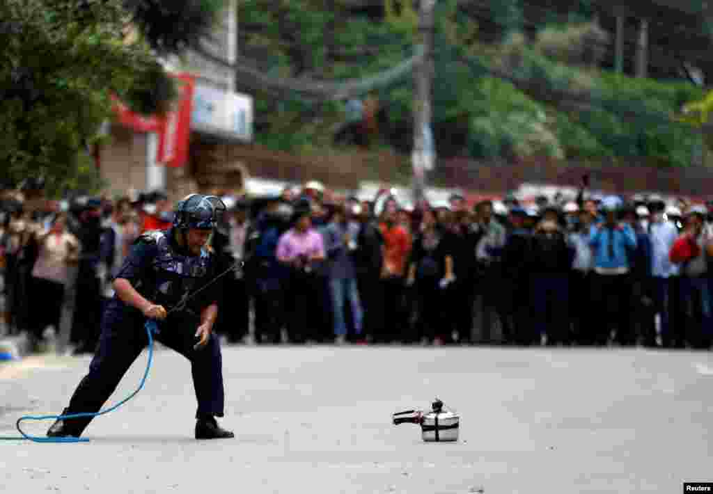 A member of the Nepalese police force checks a pressure cooker suspected of being an improvised bomb during a bomb scare in Lalitpur.