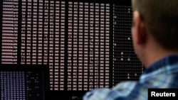 FILE - An analyst looks at code in the malware lab of a cyber security defense lab.