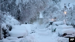 Snow-covered cars are parked after heavy snowfall in Munich, Germany, on Dec. 2, 2023.