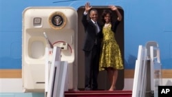 Presiden Obama dan Ibu Negara Michelle melambaikan tangan sebelum memasuki pesawat Air Force One yang akan segera bertolak menuju Afrika Selatan dari Dakar, Senegal (28/6).
