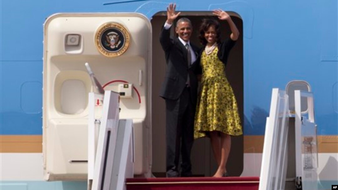 Presiden Obama dan Ibu Negara Michelle melambaikan tangan sebelum memasuki pesawat Air Force One yang akan segera bertolak menuju Afrika Selatan dari Dakar, Senegal (28/6).
