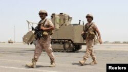 FILE - Soldiers from the United Arab Emirates walk past a military vehicle at the airport of Yemen's southern port city of Aden, Aug. 12, 2015. 