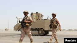 Soldiers from the United Arab Emirates walk past a military vehicle at the airport of Yemen's southern port city of Aden, Aug. 12, 2015. 