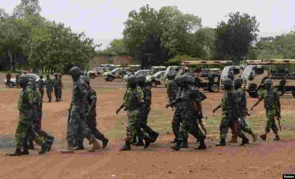Soldiers part of an expected 1,000 reinforcements sent to Adamawa state to fight Boko Haram, walk near trucks as they arrive with the 23rd Armoured Brigade in Yola May 20, 2013.