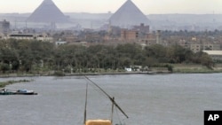 A traditional felucca boat carries a cargo of hay as it transits the Nile river, passing the Pyramids of Giza in Cairo, Egypt, January 2013.