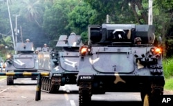 Tanks arrive at a military camp to reinforce government troops who are battling Muslim militants who laid siege in Marawi city for more than a week, May 31, 2017, in southern Philippines. Fighting continues for the second week with casualties on both sides.