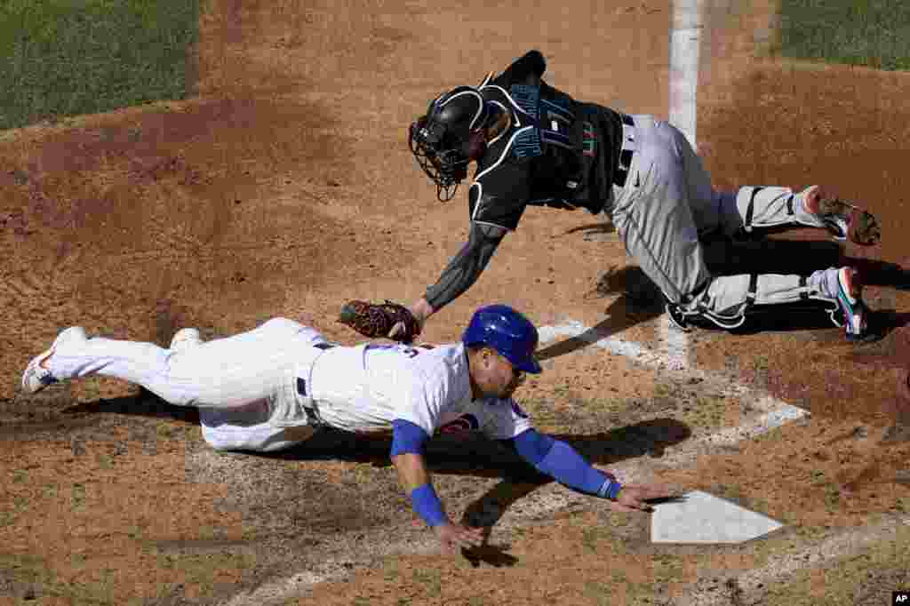 Chicago Cubs&#39; Willson Contreras, bottom, is tagged out before reaching home by Miami Marlins catcher Chad Wallach (17) during the fourth inning in Game 2 of a National League wild-card baseball series Friday, Oct. 2, 2020, in Chicago. (AP Photo/Nam Y. Huh)