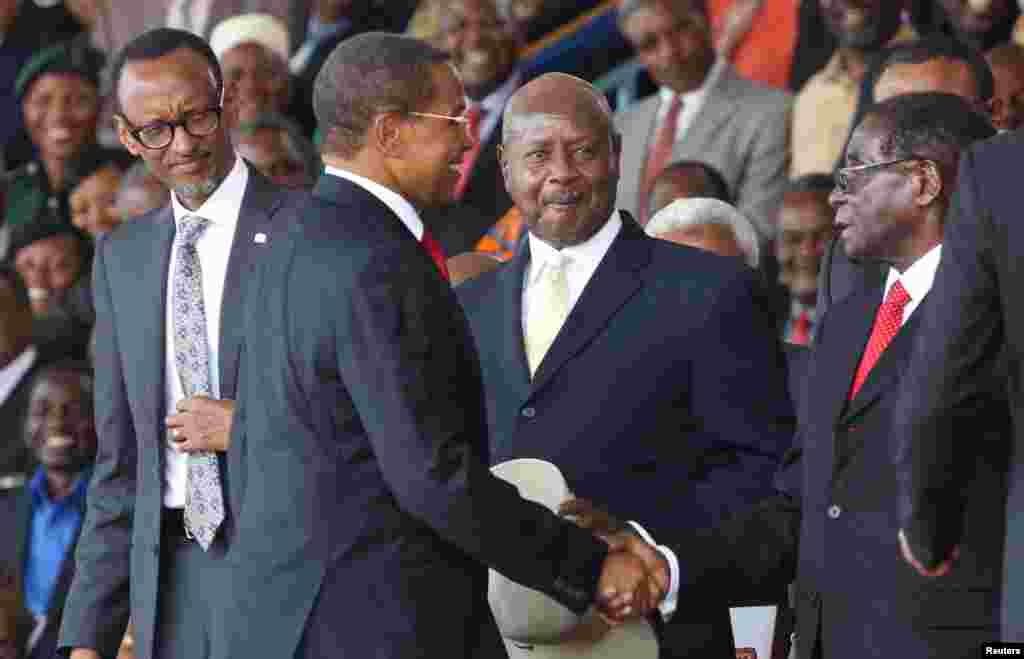 Le président Paul Kagame du Rwanda (G) et le Président Yoweri Museveni de l'Ouganda (2e D) regardent le président sortant, Jakaya Kikwete de la Tanzanie (2ème G) saluer le président Robert Mugabe du Zimbabwe avant la cérémonie d'investiture du président élu John Magufuli au Stade Uhuru à Dar es Salaam, 5 novembre 2015. REUTERS / Emmanuel Herman - RTX1UW75