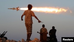 FILE - Fighters of Libyan forces allied with the U.N.-backed government fire a rocket at Islamic State fighters in Sirte, Libya, Aug. 4, 2016.