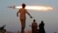 FILE - Fighters of Libyan forces allied with the U.N.-backed government fire a rocket at Islamic State fighters in Sirte, Libya, Aug. 4, 2016.