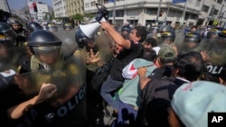 Manifestantes antigubernamentales se enfrentan a la policía mientras se dirigen al Congreso, en el marco de la cumbre de Cooperación Económica Asia-Pacífico (APEC) en Lima, Perú, el miércoles 13 de noviembre de 2024. (AP/Fernando Vergara).