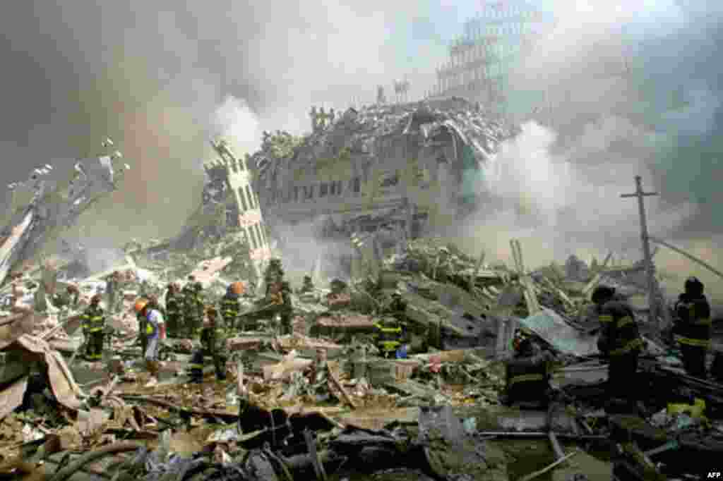 Firefighters make their way through the rubble after terrorists crashed two airliners into the World Trade Center in a deadly series of blows Tuesday that brought down the twin 110-story towers in New York Tuesday, Sept. 11, 2001. (AP Photo/Shawn Baldwin)