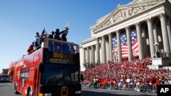 Fans cheer as Washington Nationals first baseman Ryan Zimmerman holds up the World Series trophy during a parade to celebrate the team's World Series baseball championship over the Houston Astros, Nov. 2, 2019, in Washington. 