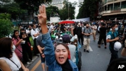 Pro-democracy demonstrators flash a three-finger salute of defiance during a protest rally in the Silom business district of Bangkok, Thailand, Thursday, Oct. 29, 2020. The protesters continue to gather Thursday with their three main demands of…