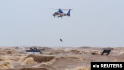 A military helicopter rescues sailors of a submerged ship at Cua Viet Port in Quang Tri province, Vietnam, Oct. 11, 2020.