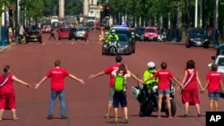 In this image made from video, climate change protesters block the car containing Britain's Conservative Party leader Boris Johnson on his way to meet the Queen in London, July 24, 2019. 