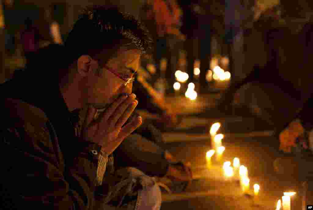 A man participates in a candle-lit vigil to mourn the death of a gang rape victim in New Delhi, Saturday, Dec. 29, 2012.