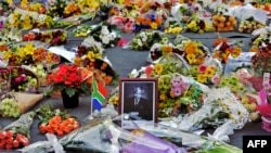 Flowers left by mourners surround a portrait of Nelson Mandela in the Sandton district of Johannesburg. Mandela, the revered icon of the anti-apartheid struggle in South Africa and one of the towering political figures of the 20th century, has died on Dec