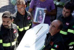 The coffin of Giulia, 9 years old, is carried outside the gymnasium at the end of the state funeral service in Ascoli Piceno, Italy, Aug. 27, 2016. As Italians observed a day of national mourning, President Sergio Mattarella and Premier Matteo Renzi joined grieving family members for a state funeral for 35 of the 290 people killed in Wednesday’s quake.