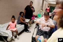 Korea War veteran, Ed Coddington, 83, second from right, and wife Esther, 78, wait with Markia McCleod, rear, her aunt Ernestine McCleod and daughter Keymoni, 4, in a shelter for Hurricane Florence to pass after evacuating from their nearby homes in Conway, S.C., Sept 12, 2018.