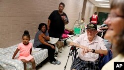 Korea War veteran, Ed Coddington, 83, second from right, and wife Esther, 78, wait with Markia McCleod, rear, her aunt Ernestine McCleod and daughter Keymoni, 4, in a shelter for Hurricane Florence to pass after evacuating from their nearby homes in Conway, S.C., Sept. 12, 2018.