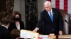 FILE - Then-U.S. Vice President Mike Pence hands an electoral certificate to Senator Amy Klobuchar as he presides over a joint session of Congress as it convenes to count the Electoral College votes cast in the 2020 presidential election, in Washington on Jan. 6, 2021.