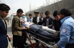 An injured man is being moved toward an ambulance, after an attack in Kabul, Afghanistan, March 6, 2020.