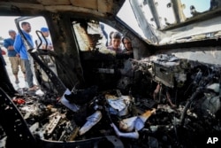 FILE— People inspect the site where World Central Kitchen workers were killed in Deir al-Balah, Gaza Strip, Tuesday, April 2, 2024.