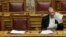 Greek Finance Minister Yanis Varoufakis reads papers during a parliament session in Athens, April 2, 2015. 
