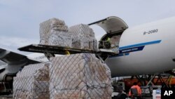 FILE - In this April 10, 2020, file photo, a ground crew at Los Angeles International Airport unload pallets of medical personal protective equipment from a China Southern Cargo plane upon its arrival in Los Angeles.