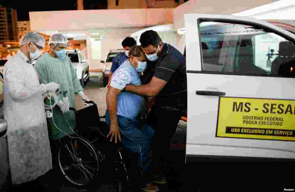 Yawalapiti chief Aritana, suffering from COVID-19, is supported by a doctor, Celso Correia Batista, outside the Sao Francisco de Assis hospital in Goiania, Brazil, July 22, 2020.