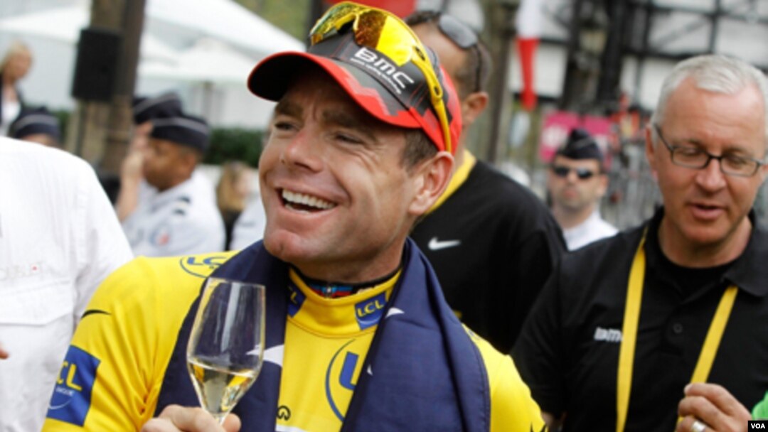 Juara Tour de France Cadel Evans dari Australia diberi minuman anggur di Champs Elysees dalam parade kemenangan di Paris, Minggu (24/7).