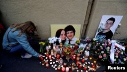 FILE PHOTO: A woman kneels by a memorial on the first anniversary of the murder of the investigative reporter Jan Kuciak and his fiancee Martina Kusnirova in Bratislava, Slovakia, Feb. 21, 2019. 