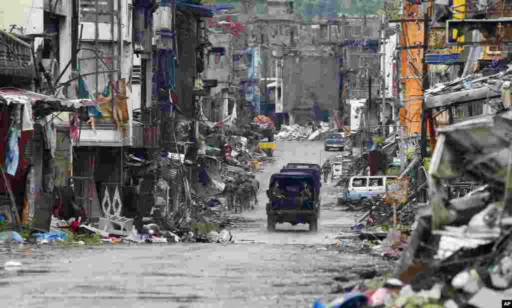 Amidst the ruins at "Ground Zero," Philippine troops return to their deployment after attending the ceremony where President Rodrigo Duterte declared the liberation of Marawi city in southern Philippines after almost five months of a siege by pro-Islamic State group militants.