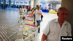 La inflación tiende a subir en Venezuela, a la par de la escasez de bienes de primera necesidad como puede verse en esta fila en un supermercado de Caracas.