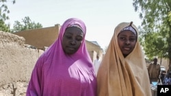 Um das meninas libertadas pelo Boko Haram caminha com a sua mãe, Dapchi, 21 de Março 21, 2018