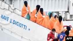 Des migrants descendent du bateau de sauvetage "Diciotti" en Italie, le 8 janvier 2018.