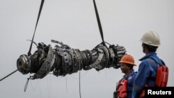 Rescue team members stand during lifting-up an turbine engine of Lion Air flight JT610 at the north coats of Karawang, Indonesia, Nov. 3, 2018. 