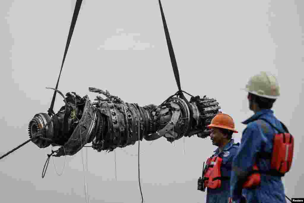 Dua anggota tim penyelamat mengamati sementara mesin pesawat Lion Air JT610 diangkat di pantai utara, Karawang, Jawa Barat, Sabtu (3/11). (Foto: Antara/Reuters).&nbsp;