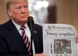 Tổng thống Trump giơ tờ báo The Washington Post với bản tin trang nhất về việc ông được xử trắng án trong phiên xét xử luận tội ở Thượng viện, khi ông phát biểu về sự kiện này trong Phòng Đông của Nhà Trắng ở Washington, ngày 6 tháng 2, 2020.