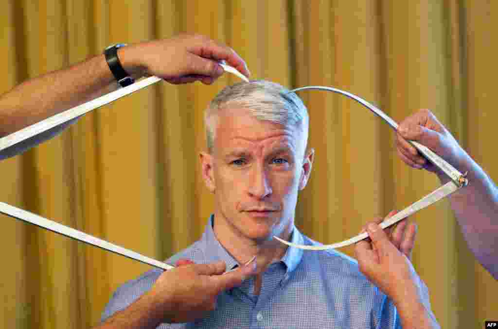 Nhà báo truyền hình Anderson Cooper ngồi yên cho các chuyên viên đo đạc để nắn tượng trưng bày tại nhà triển lãm tượng sáp Madame Tussauds ở New York. REUTERS/Lucas Jackson