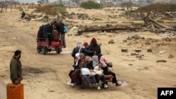 People ride in the back of a tricycle transporting them from Nuseirat to Gaza City on Feb. 10, 2025 as displaced people return home amid the current ceasefire deal in the war between Israel and Hamas.