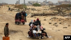 People ride in the back of a tricycle transporting them from Nuseirat to Gaza City on Feb. 10, 2025 as displaced people return home amid the current ceasefire deal in the war between Israel and Hamas.