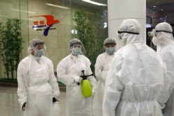FILE - State Commission of Quality Management staff in protective gear and with disinfectant prepare to check the health of travelers arriving from abroad at the Pyongyang Airport in Pyongyang, North Korea, Feb., 1, 2020.